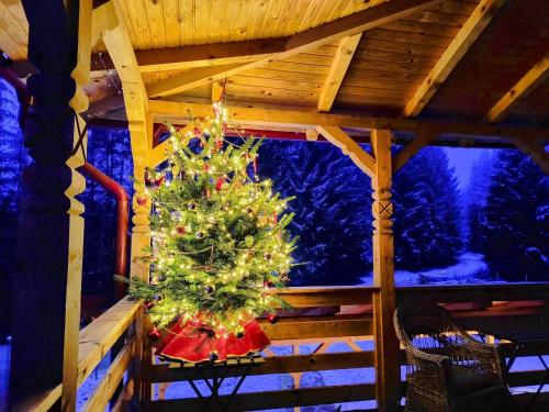 a christmas tree on the porch of a cabin at Poiana Sașilor - Valea Doftanei in Trăisteni