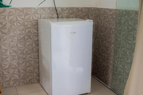 a white refrigerator in a kitchen next to a wall at Hotel Fazenda Pé da Serra in Bom Sucesso
