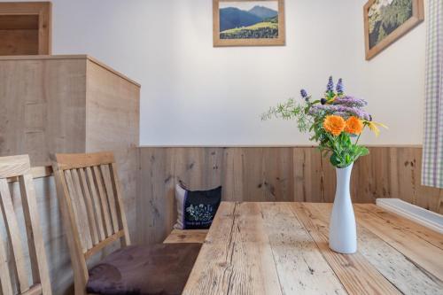 a vase of flowers sitting on a wooden table at Bauernhof Pergila in Maria Luggau