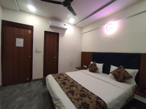 a bedroom with a large bed and a brown door at Hotel Earth Inn, Subhash Bridge, RTO Circle, Ahmedabad in Ahmedabad