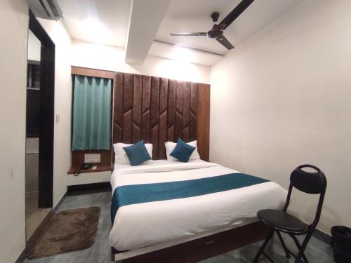 a bedroom with a large bed with a wooden headboard at Hotel Earth Inn, Subhash Bridge, RTO Circle, Ahmedabad in Ahmedabad