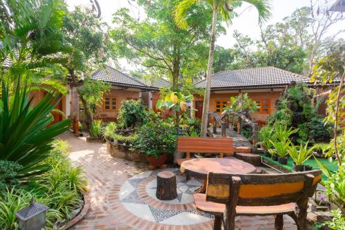 a garden with a table and chairs in front of a house at Duy Ngoc Resort Phu Quoc in Phu Quoc