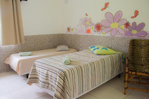 two beds in a room with flowers on the wall at Hotel Fazenda Pé da Serra in Bom Sucesso