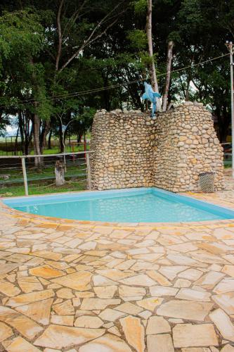 a blue teddy bear sitting on top of a wall at Hotel Fazenda Pé da Serra in Bom Sucesso