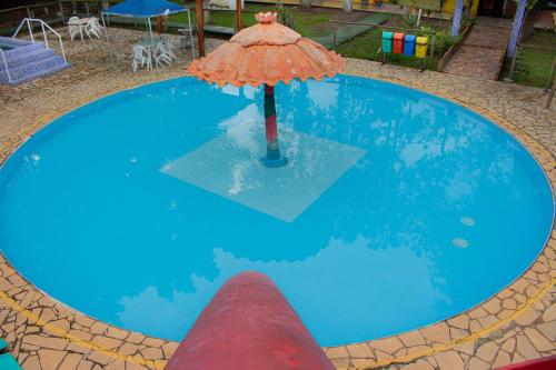 an umbrella in the middle of a swimming pool at Hotel Fazenda Pé da Serra in Bom Sucesso