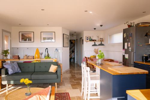 une cuisine et un salon avec un canapé et une table dans l'établissement Côte et Rôve Maison mignon au bord de mer, à Plouhinec