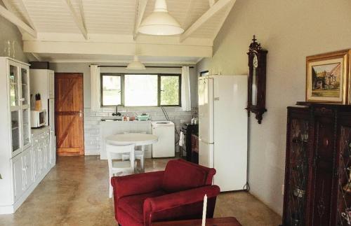 a living room with a red couch and a table in a kitchen at Peter's Gate Farm Cottage in Lidgetton