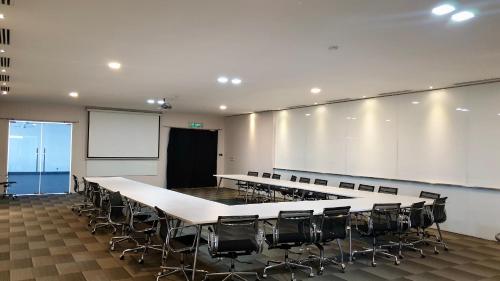 a conference room with tables and chairs and a whiteboard at M City Ampang KLCC Lake view Pool in Kuala Lumpur