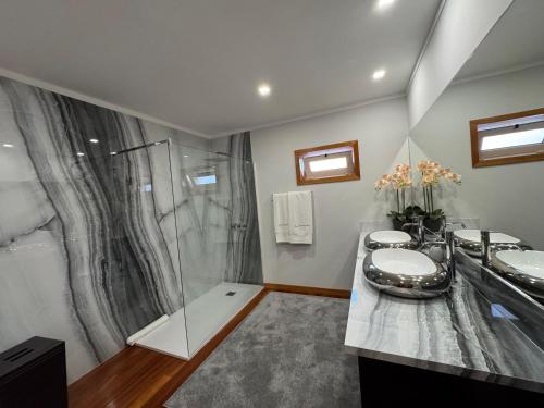 a bathroom with two sinks and a shower at Casa Serra dos Picos - Casa de Ferias, Braga in Braga