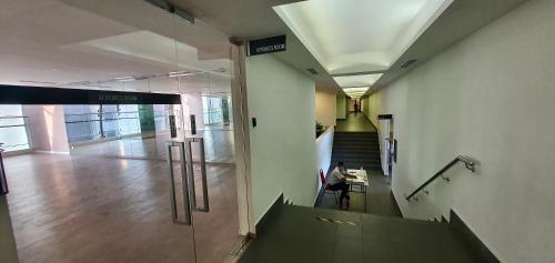 a hallway in a building with a person sitting at a desk at M City Ampang KLCC Lake view Pool in Kuala Lumpur