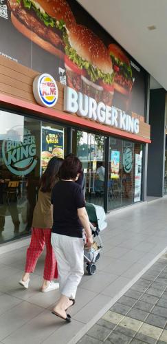 a group of people walking in front of a burger king at M City Ampang KLCC Lake view Pool in Kuala Lumpur