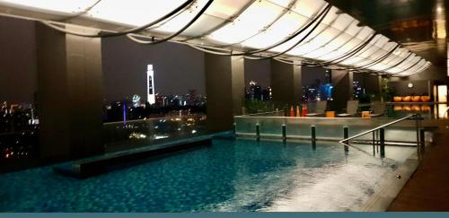 a swimming pool in a building with a city skyline at M City Ampang KLCC Lake view Pool in Kuala Lumpur