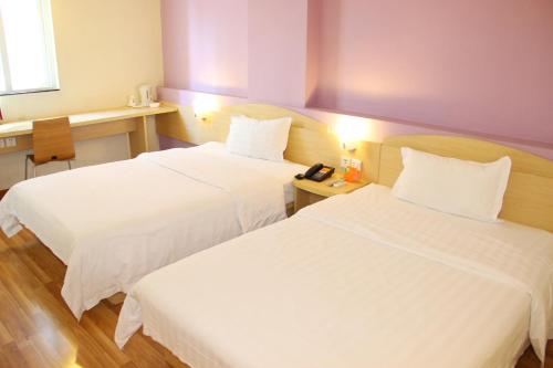 a hotel room with two beds and a telephone at 7Days Premium Guangzhou Tianhe Shipaiqiao in Guangzhou