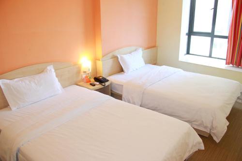 a hotel room with two beds and a window at 7Days Premium Guangzhou Tianhe Shipaiqiao in Guangzhou