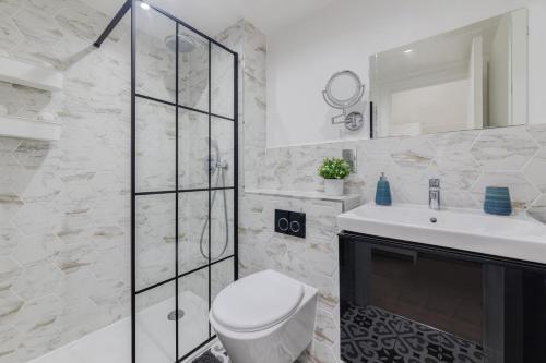 a white bathroom with a toilet and a sink at 1 Bedroom Penthouse Apartment - Shoreditch, London by The Perfect Stay in London