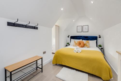 a bedroom with a yellow bed with a blue headboard at 1 Bedroom Penthouse Apartment - Shoreditch, London by The Perfect Stay in London