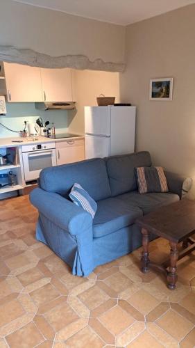 a living room with a blue couch in a kitchen at Domaine du Bois d'Amont in Cabris