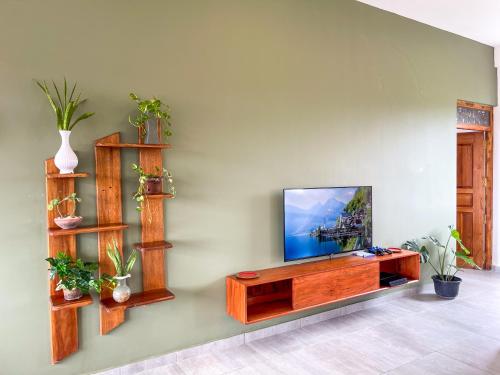 a living room with a flat screen tv on a wall at Twenty- Two Swiss Residence in Weligama