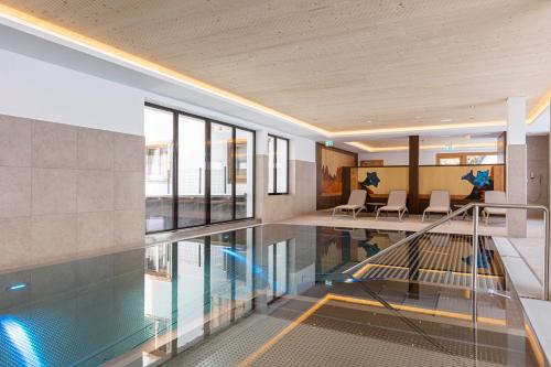 an indoor swimming pool in a building with glass floors at Bergresort Tauernblick by ALPS RESORTS in Mittersill