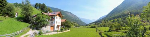 a house in a field with mountains in the background at Ferienwohnungen Auhaus in Martello
