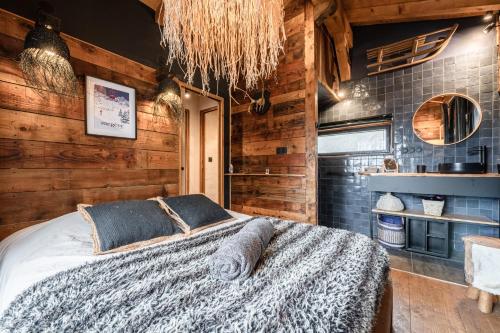 a bedroom with a bed in a room with wooden walls at Chalet Etailya au coeur des pistes du Jaillet in Megève