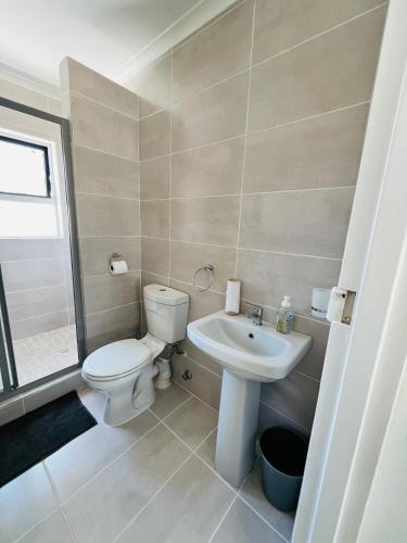a bathroom with a toilet and a sink at Private garden guest house in Cape Town