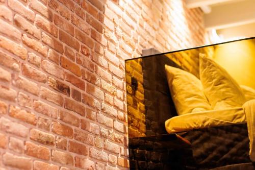 a brick wall with a mirror next to a couch at City Spa Nijmegen in Nijmegen