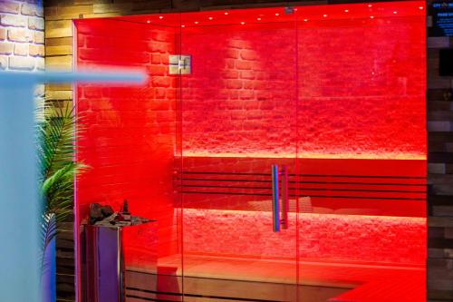a glass shower with red paint on a brick wall at City Spa Nijmegen in Nijmegen