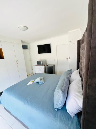 a bedroom with a blue bed with two pillows at Private garden guest house in Cape Town