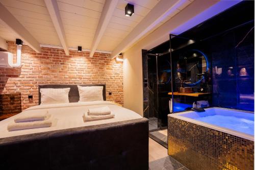 a bedroom with a large bed and a bath tub at City Spa Nijmegen in Nijmegen