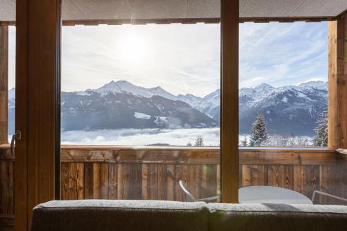a room with a window with a view of mountains at Bergresort Tauernblick by ALPS RESORTS in Mittersill