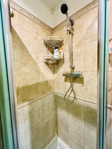 une douche avec une porte vitrée dans une salle de bain dans l'établissement Lecourbe Porte de Versailles, à Paris