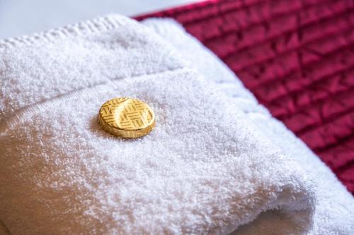 a white towel with a cookie on top of it at The Jewellery Suites Birmingham in Birmingham