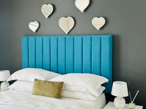 ケープタウンにあるBig Bay Beach Clubの青いヘッドボード(壁にハート付)が備わるベッドルーム1室