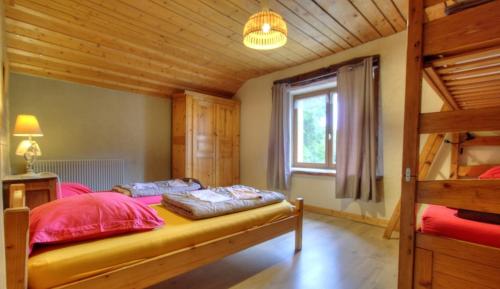 a bedroom with a bed and a wooden ceiling at La Grange des Plans in Le Grand-Abergement