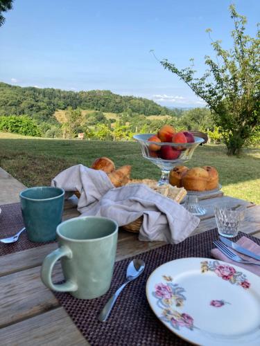 サリー・ド・ベアムにあるDomaine Labouroumeの食べ物の皿とリンゴのボウルが置かれたピクニックテーブル