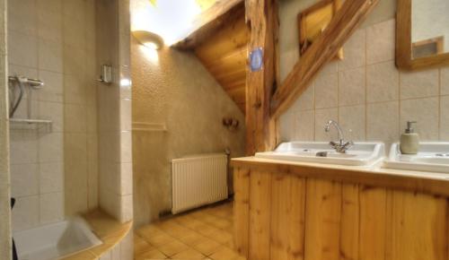 a bathroom with a sink and a bath tub at La Grange des Plans in Le Grand-Abergement