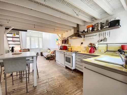 une grande cuisine avec une table et un comptoir dans l'établissement Riquette, à Le Touquet-Paris-Plage