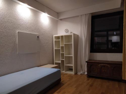 a bedroom with a bed and a cabinet and a television at Rheinblickhouse in Beuggen