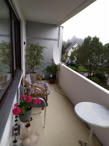 a balcony with a chair and a table and a window at Rheinblickhouse in Beuggen