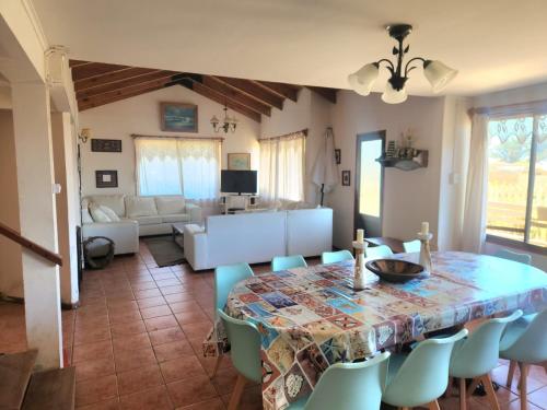 una sala de estar con una mesa y sillas en PICHILEMU BEACH HOUSE, en Pichilemu
