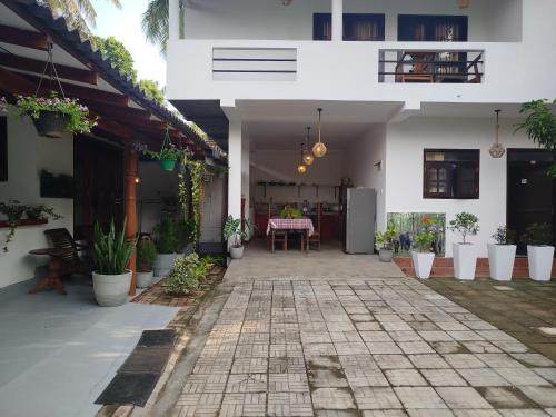 a courtyard of a house with potted plants at Little Villa Guest House in Ahangama