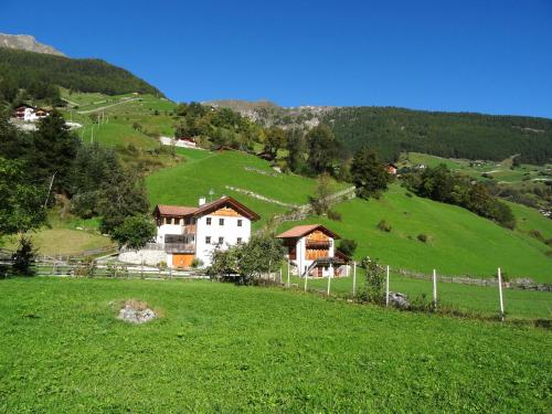 a house on a hill in a green field at Ferienwohnungen Auhaus in Martello