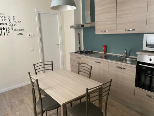 a kitchen with a table and chairs in a kitchen at Appartamento Anna - Comfort e Stile in Centro Storico in Imola