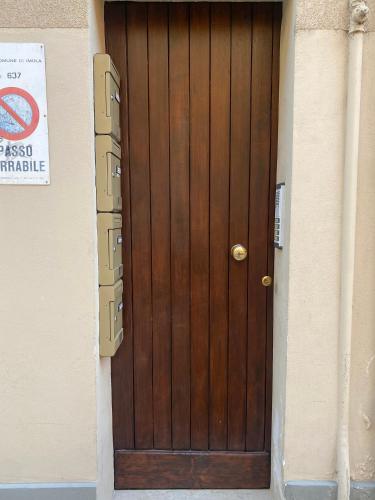 a wooden door in a building with a sign on it at Appartamento Anna - Comfort e Stile in Centro Storico in Imola