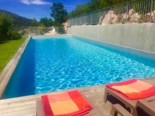 - une grande piscine bleue avec 2 chaises dans l'établissement Duplex Vista, à Bonifacio