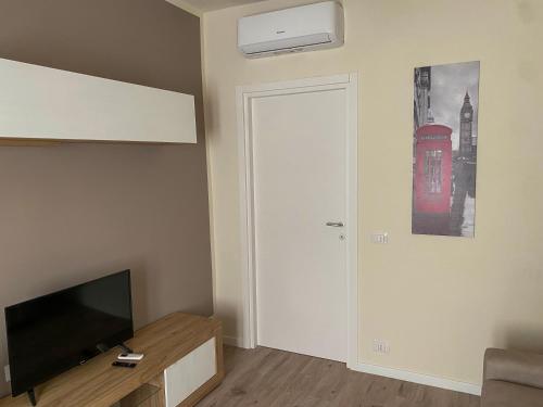 a living room with a television and a door with a picture at Appartamento Anna - Comfort e Stile in Centro Storico in Imola