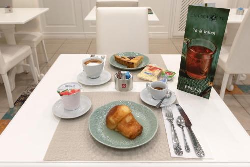 a table with a plate of food and cups of coffee at Certosa Suite in Naples