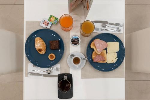 a table with two plates of breakfast foods and drinks at Certosa Suite in Naples