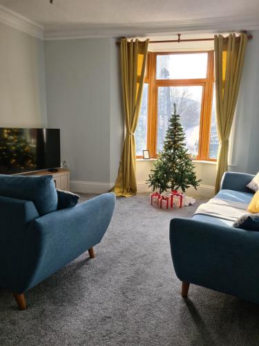 a living room with a christmas tree and a couch at Spacious Mytholmroyd Apartment with River Views in Mytholmroyd